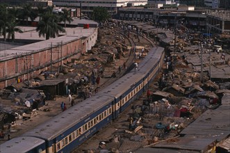 BANGLADESH, Dhaka, Tejgaon, Train passing through overcrowded slum housing lining the railway track