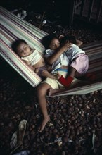 PERU, Loreto, Iquitos, Three young children sleeping in hammock.