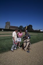 ENGLAND, East Sussex, Battle, Battle Abbey. Saxon foot soldier talking to visitors in the grounds