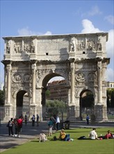 ITALY, Lazio, Rome, Tourists at the base of the 3rd century Arch of Constantine outside the Forum