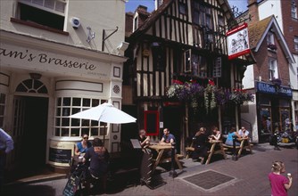 ENGLAND, East Sussex, Hastings, Old Town. George Street. Pubs and restaturants with people sitting