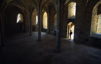 ENGLAND, East Sussex, Battle, Battle Abbey. The novice's room with a lone man seen standing under a