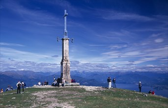 ITALY, Piedmont, Monte Mottarone, Tourists at summit of Monte Mottarone marked by tower and cross