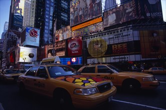 USA, New York, New York City, Times Square.  Yellow taxi cabs on street lined with skyscraper