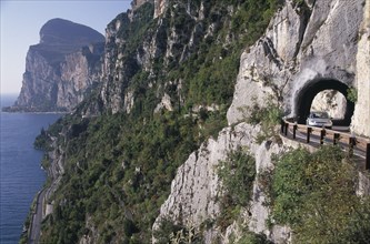 ITALY, Lombardy, Lake Garda Area, Car on high Gardesana Occidentale road with tunnels through cliff