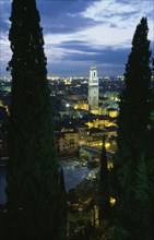 ITALY, Veneto, Verona, "Cityscape illuminated at night showing tiled rooftops, Duomo bell tower and