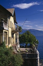 ITALY, Lake Maggiore, Part view of yellow painted exterior facade of villa with stone balustrade