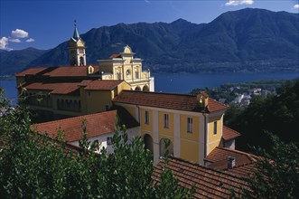 SWITZERLAND, Ticino, Lake Maggiore, Locarno.  Tiled rooftops and bell tower of yellow and white