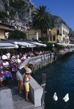 ITALY, Lombardy, Lake Garda , Limone Sur Garda.  Busy lakeside cafe with people sitting at tables