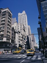 USA, New York, View along 5th Avenue in-between tall buildings with yellow taxi cabs on road and