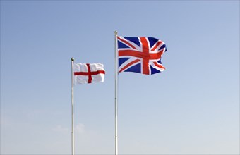 WEATHER, Climate, Wind, British Union Jack and St George Cross flags fyling against a blue sky