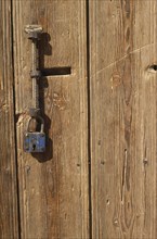 TURKEY, Cappadocia, Cavusin, Detail of wooden door with metal handle and padlock.