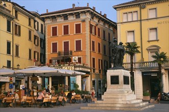 ITALY, Lombardy, Salo, "People sitting at outside cafe tables in piazza of town beside Lake Garda.
