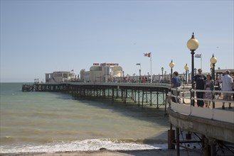 ENGLAND, West Sussex, Worthing, People walking along the promenade deck on Worthing Pier