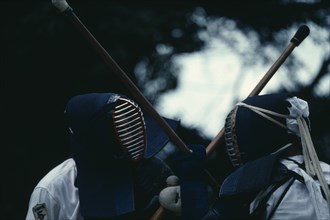JAPAN, Samurai, Kendo, Two opponents in bogu armour facing each other over crossed shinai bamboo