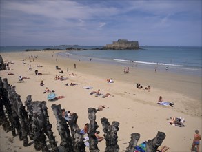 FRANCE, Brittany, St Malo, Le Sillon Beach and Fort National. Sunbathers on golden sand
