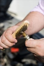 TRANSPORT, Road, Cars, Man cleaning a sparkplug with a wire brush