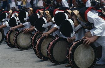 JAPAN, Kyushu, Kaseda Shrine, Line of bowed musicians at village festival.  In feudal times Kyushu