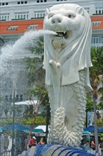 SINGAPORE, MERLION STATUE , "SITUATED INFRONT OF THE FULLERTON HOTEL AND FINACIAL DISTRICT BEHIND.