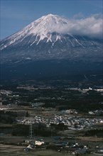 JAPAN, Honshu, Mount Fuji, Snow capped peak of Mount Fuji rising up behind houses and agricultural