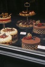 SWITZERLAND, Ticino, Lugano, Display of cakes and pastries in window.