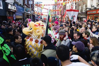ENGLAND, London, Chinatown, Crowds passing under paper lanterns hung around one of the oriental