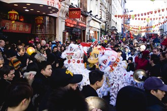 ENGLAND, London, Chinatown, Lion Dance troupe performing in Wardour Street with onlooking crowd