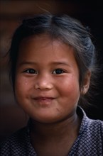 NEPAL, Kathmandu, Head and shoulders portrait of smiling young Gurkha girl.