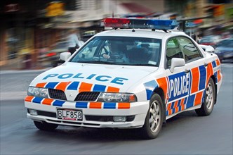 NEW ZEALAND, SOUTH ISLAND, OTAGO, "QUEENSTOWN, A NEW ZEALAND POLICE CAR AND OFFICER SPEEDS PAST