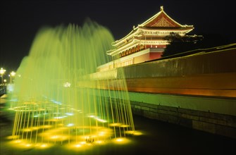 CHINA, Beijing, Entrance to the Forbidden City and fountain illuminated at night.