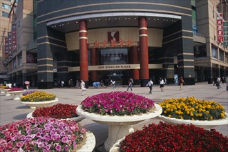 CHINA, Beijing, Raised circular flower beds outside Sun Dong an Plaza shopping mall entrance on