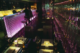 CHINA, Beijing, Tou Ming Si Kao ( TMSK ) bar interior with couple sitting at glass bar illuminated