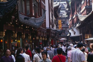 CHINA, Shanghai, "Yu Gardens, Old City.  Crowds of shoppers in narrow street lined with shop fronts