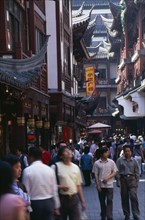 CHINA, Shanghai, "Yu Gardens, Old City.  Crowds of shoppers on narrow street lined by buildings