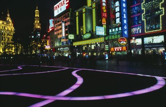 CHINA, Shanghai, "Nanjing Lu.  Street scene at night with illuminated coloured pavement trail, neon