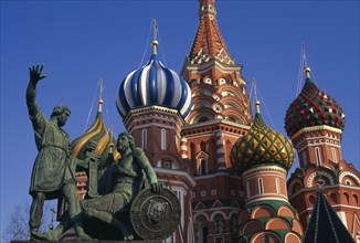 RUSSIA, Moscow, St Basil’s Cathedral.  Detail of onion dome spires and statue.