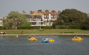 ENGLAND, West Sussex, Littlehampton, Families enjoying pedal boat rides at Oyster Pond Boating Lake