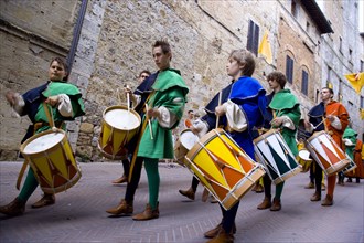 ITALY, Tuscany, San Gimignano, Boys and young men in Medieval costume beating drums in a parade