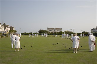 ENGLAND, West Sussex, Bognor Regis, Men and women playing a game of bowls on beach front green