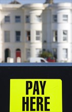 ENGLAND, West Sussex, Littlehampton, Yellow car park sign with black writing saying Pay Here with