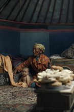 MONGOLIA, People, Khalkha winter sheep camp  ger yurt interior with grandmother looking after