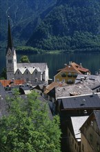 AUSTRIA, Oberosterreich, Hallstatt, "View over tiled village rooftops, hotel and church with