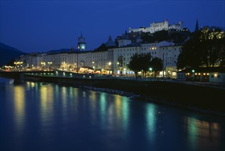 AUSTRIA, Salzburg, City view at night with green and yellow lights of river side street lamps and
