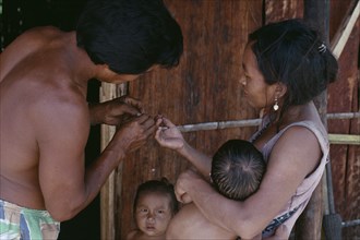 COLOMBIA, North West Amazon, Tukano Indigenous People, Makuna family.  Venancio removing thorn from