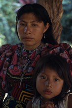 COLOMBIA, Darien, Kuna Indians, Portrait of Kuna mother and young daughter wearing brightly