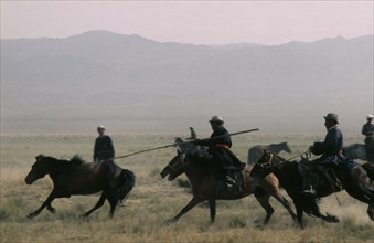 MONGOLIA, Gobi Desert, Biger Negdel, "Khalkha horsemen galloping at full stretch to round up wild