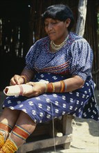 PANAMA, San Blas Islands, Kuna Indians, Older Kuna Indian woman preparing traditional bead design.