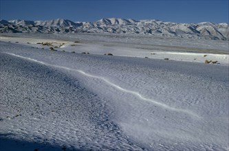 MONGOLIA, Gobi Desert, Biger Negdel, Mid-winter with snow-covered desert pastures. Onvoy of trucks