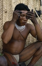 COLOMBIA, North West Amazon, Tukano Indigenous People, "Barasana man looking in mirror to apply red