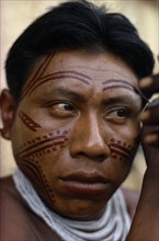 COLOMBIA, North West Amazon, Tukano Indigenous People, Barasana man applying dark red Achiote